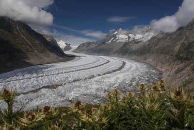 Scenic view of snow covered mountain range against sky