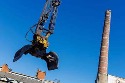 Low angle view of crane against clear sky