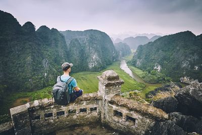 Man looking at mountains against sky