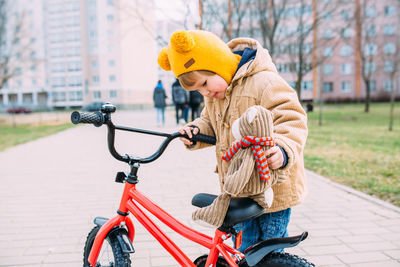 A small child learns to ride a bike for the first time in the city in spring