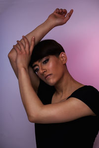 Low angle view of young woman against gray background