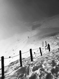 Silhouette people on snow covered land against sky