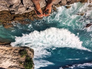 Low section of human legs against water