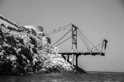 Bridge over sea against clear sky