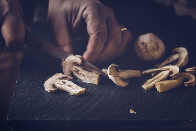 Cropped image of chef cutting mushroom