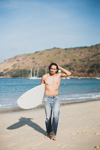 Portrait of young man standing at beach