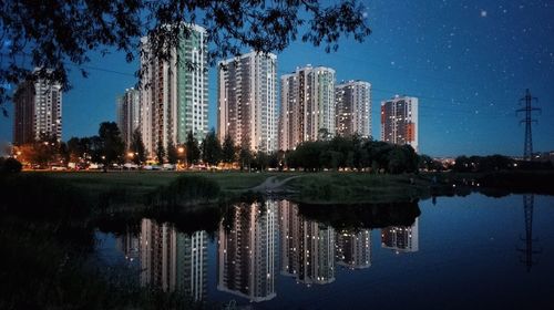 Reflection of buildings in city against sky