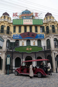 People on street against buildings in city