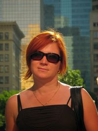Portrait of woman wearing sunglasses standing in city