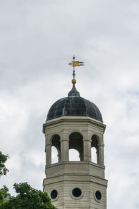 Low angle view of bell tower by building against sky