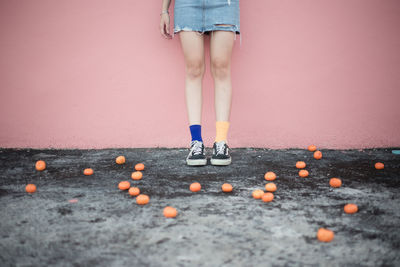 Low section of woman leaning on wall