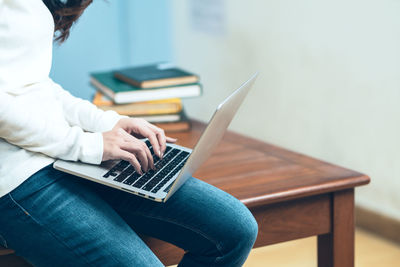 Man using mobile phone while sitting on table