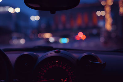 View of illuminated city seen from inside of the car at night