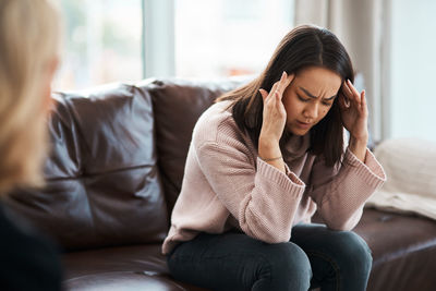 Frustrated woman sitting on sofa