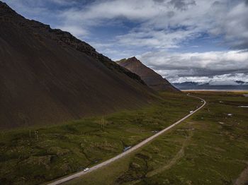 Scenic view of road by mountains against sky
