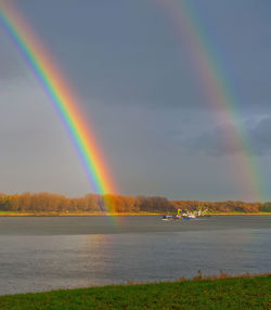 Rainbow over lake against sky