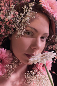 Close-up portrait of beautiful woman smelling flowers