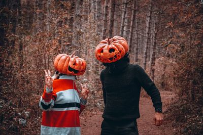 Full length of a boy standing by pumpkin