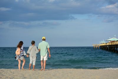 Rear view of family standing on beach