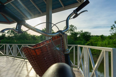 Bicycle by railing against sky