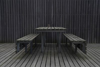 Empty chairs and table against wall