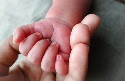 Close-up of parent holding baby hand