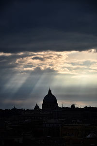 Silhouette of temple against cloudy sky