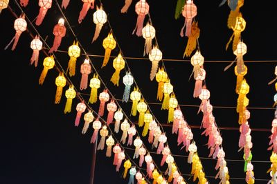 Low angle view of illuminated colorful lanterns hanging against sky at night