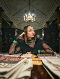 Portrait of young woman sitting on table