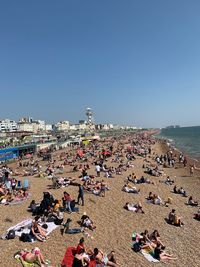 High angle view of people on beach against clear sky