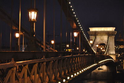 Illuminated chain bridge against sky at night