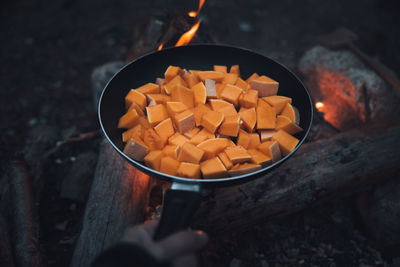 Frying pan over campfire with orange vegetables