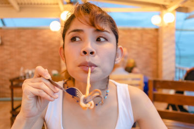 Portrait of young woman looking at restaurant