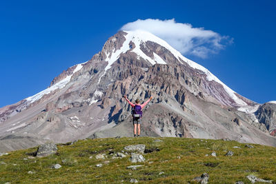 Scenic view of a girl looking at snowcapped mountains against sky