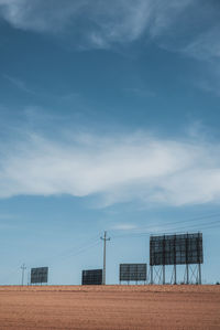 Billboards on field against sky