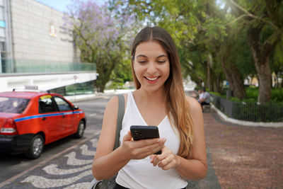 Brazilian girl using smartphone for internet banking in city center of porto alegre, brazil