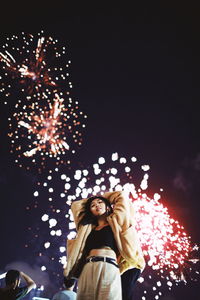 Low angle view of woman standing against sky