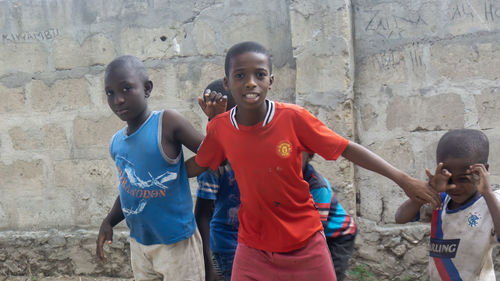 Siblings standing against wall