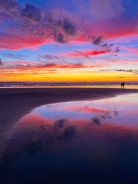 Scenic view of sea against dramatic sky during sunset