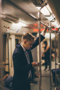 Businessman using mobile phone while traveling in train