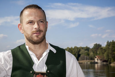 Man in traditional clothing looking away against sky