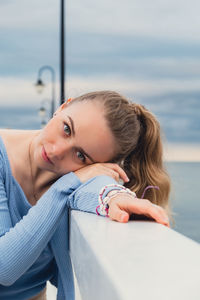 Young woman standing on wooden pier blurred beachside background. attractive female enjoying the sea