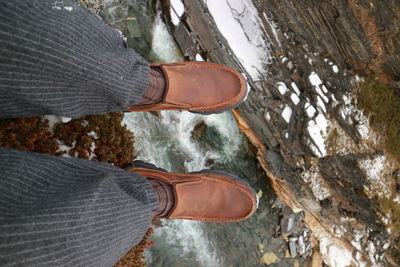 Low section of man standing by stream