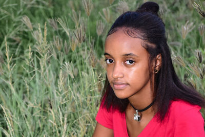 Close-up of young woman in red looking away