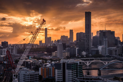 View of modern buildings against cloudy sky during sunset