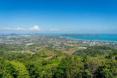 Aerial view of city and sea against blue sky