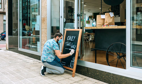 Restaurant owner writing on a blackboard