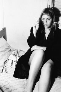 Portrait of young woman smoking cigarette while sitting at home