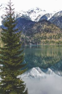 Scenic view of lake by mountains during winter