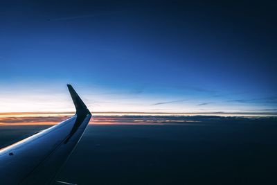 Airplane flying in sky at sunset